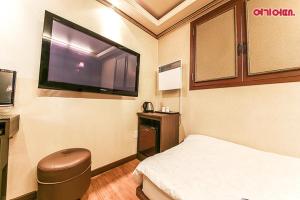 um quarto de hospital com uma cama e uma televisão de ecrã plano em Coups Hotel em Seul