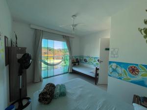 a bedroom with a bed and a window with a view at Ipê Palmas Hostel in Governador Celso Ramos