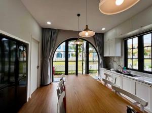 a large kitchen with a large archway in the middle at Duy Quan Villa NovaWorld Phan Thiet 04 in Bình Tú