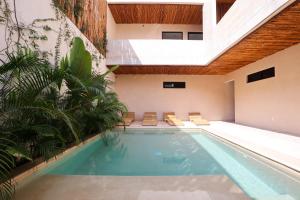 an indoor pool in a house with a vaulted ceiling at Akbal Tulum in Tulum