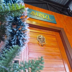 a wooden door with a sign on top of it at SUNZI BOUTIQUE HOSTEL : ซันซิ บูทีค โฮสเทล in Betong