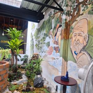 Un mur avec une peinture d'homme sur lui dans l'établissement SUNZI BOUTIQUE HOSTEL : ซันซิ บูทีค โฮสเทล, à Betong