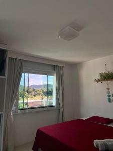 塞爾蘇拉穆斯州長鎮的住宿－Ipê Palmas Hostel，一间卧室设有一张床和一个美景窗户。