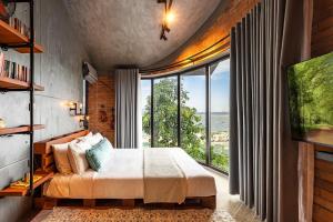 a bedroom with a bed and a large window at Ruhigen Legend Villa Vesta Collections in Phan Rang
