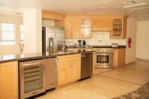 a kitchen with wooden cabinets and stainless steel appliances at Luxe Oasis: w/Pool & Lake Access in Nassau