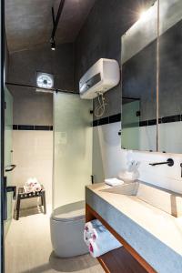 La salle de bains est pourvue d'un lavabo, de toilettes et d'un miroir. dans l'établissement Ruhigen Legend Villa Vesta Collections, à Phan Rang
