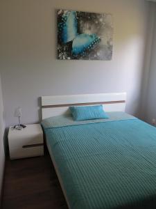 Schlafzimmer mit einem Bett mit blauer Decke in der Unterkunft Apartament Mysia in Świeradów-Zdrój