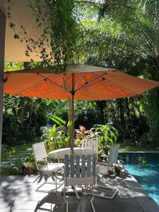 een tafel en stoelen met een parasol naast een zwembad bij Charm Villa - Fla Đại Lải in Phúc Yên