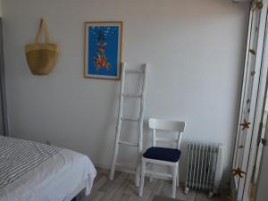 um quarto com uma escada, uma cadeira e uma fotografia em Appartement Saint-Jean-de-Monts, 2 pièces, 4 personnes - FR-1-323-448 em Saint-Jean-de-Monts