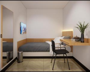 Check Inn Permata Hijau في سيمارانغ: غرفة نوم مع سرير ومكتب مع كرسي