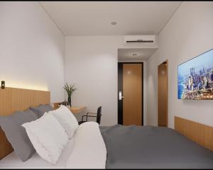 Un dormitorio con una cama y un cuadro en la pared. en Check Inn Permata Hijau, en Semarang