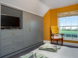 a bedroom with a tv and a bed and a window at Sunset View in Edington