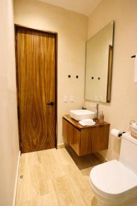 a bathroom with a toilet and a sink and a mirror at Akbal Tulum in Tulum