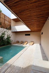 an indoor swimming pool with a wooden ceiling at Akbal Tulum in Tulum