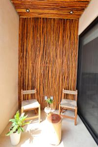 two chairs and a table in a room with a curtain at Akbal Tulum in Tulum