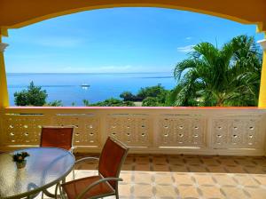 balcón con mesa y sillas y vistas al océano en Camotes Serenity, en Islas Camotes