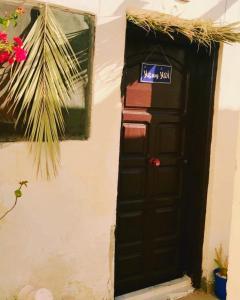Una puerta negra en una pared con un cartel. en Moon el mashraba, en Dahab