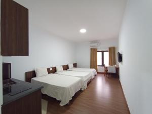 um quarto de hotel com duas camas e uma cozinha em Khách sạn Hữu Nghị em Vinh