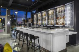 a bar with stools in a room with a view at Aloft Glendale at Westgate in Glendale