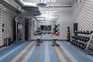 a room with a gym with exercise equipment in it at Aloft Glendale at Westgate in Glendale
