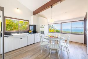 une cuisine et une salle à manger avec une table et des chaises dans l'établissement Casa Carinho, 24 Wallawa Rd - spectacular water views, pet friendly, air con and Wi-Fi, à Nelson Bay