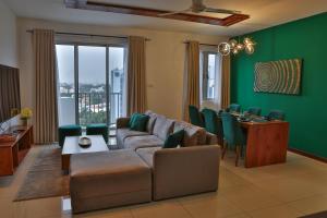 a living room with a couch and a table and chairs at EMERALD@On320 in Colombo +9 photos