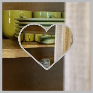 una ventana con forma de corazón en un armario con platos en ALMA CALMA en San Marcos Sierras
