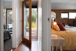 1 dormitorio con 1 cama y puerta que conduce a un porche en The Homestead en Franklinford