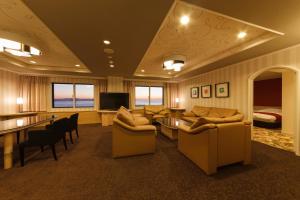 ein Wohnzimmer mit Sofas und einem TV sowie ein Schlafzimmer in der Unterkunft Grand Mercure Minamiboso Resort & Spa in Minamiboso