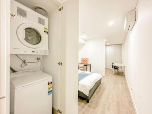 Zimmer mit einem Bett und einer Waschmaschine in der Unterkunft Burword Suites Free Parking in Sydney