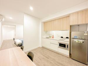 eine Küche mit einem langen Tisch und einem Kühlschrank in der Unterkunft Burword Suites Free Parking in Sydney