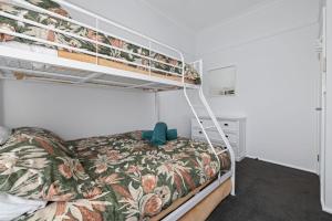 a bedroom with a bunk bed with a floral bedspread at Snow-Berri in Berridale