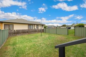 a yard with a fence and a house at Snow-Berri in Berridale