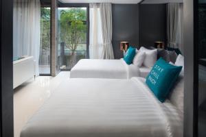 2 camas blancas en una habitación con ventana en Cross Vibe Pattaya Seaphere - formerly X2 Vibe Pattaya Seaphere, en Na Jomtien