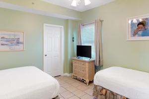 - une chambre avec 2 lits et une télévision sur une commode dans l'établissement South Harbour 2A, à Pensacola Beach