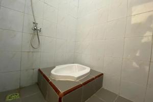 uma pequena casa de banho com chuveiro e WC em SPOT ON 93452 Wulan Homestay 2 Syariah em Tegal