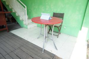 einem roten Tisch mit einem Laptop darüber in der Unterkunft SPOT ON 93423 Kost Berkah in Lawang