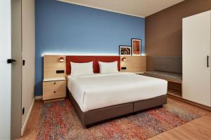 Un dormitorio con una gran cama blanca y una pared azul en Residence Inn by Marriott Munich Central, en Múnich