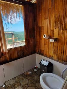 een badkamer met een toilet en een raam met uitzicht bij Wanagiri sunset glamping in Gitgit