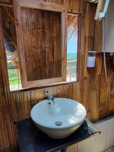 een witte wastafel in een houten badkamer met een raam bij Wanagiri sunset glamping in Gitgit