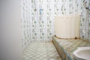 ein Badezimmer mit einem Heizkörper und Blumen an der Wand in der Unterkunft SPOT ON 93423 Kost Berkah in Lawang
