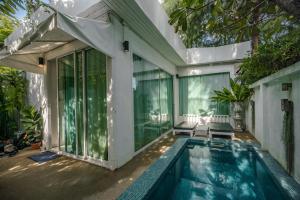 an exterior view of a house with a swimming pool at Green Gallery Beach Boutique Hotel in Hua Hin