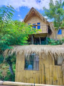 a thatch roofed house with a thatched roof at Wanagiri sunset glamping in Gitgit