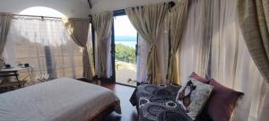 a bedroom with a bed and a large window at GLAMPING Aldea Muisca in Tota