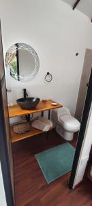 y baño con lavabo, aseo y espejo. en GLAMPING Aldea Muisca, en Tota
