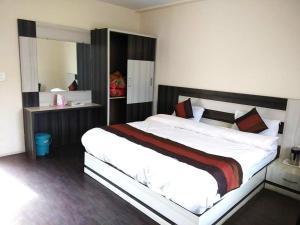um quarto com uma cama grande num quarto em Aromo's S N Resort em Dharamshala