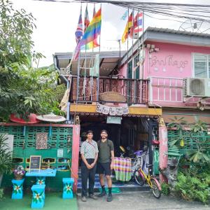 2 personnes debout devant un bâtiment dans l'établissement Ban Kru Ae Homestay, à Bangkok