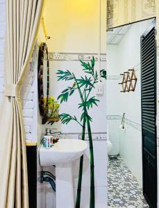 Homestay Tí Nị في Tây Ninh: حمام فيه مغسلة و نخلة