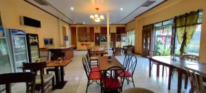 a restaurant with tables and chairs in a room at OYO 1038 WILLIAM HEARTS PENSION in Puerto Princesa City