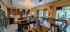 un restaurante con mesas y sillas en una habitación en OYO 1038 WILLIAM HEARTS PENSION en Puerto Princesa